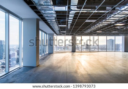 Vacant office space offering views of the city. Open ceiling showing ventilation system. Shot just after construction was completed on a late winter afternoon in downtown Montreal, Quebec, Canada.
