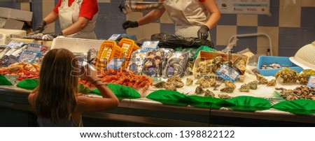 Young Girl taking Photograph at a Fish Market in Barcelona Spain