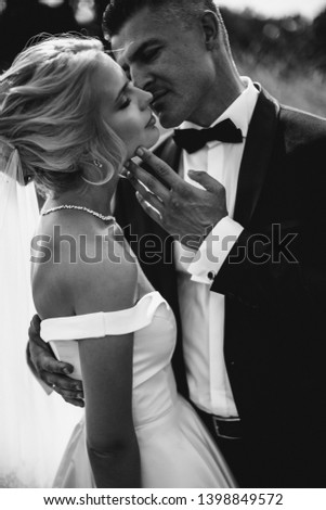 Newlyweds are kissing. Black and white picture.