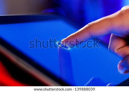 Close-up image of finger touching blue screen