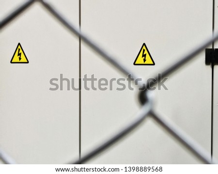 Warning label of high electrical voltage in an iron fence.