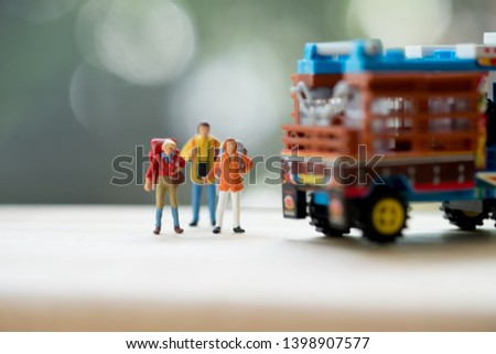 Miniature people : Traveler with backpack standing next to Thai farming trucks, Travel and Adventure concepts in Thailand and hitchhiking concept