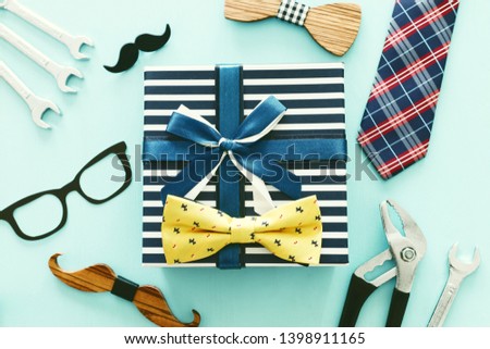 Father's day concept. Hipster glasses, gift box, tie and funny moustache over wooden background. top view, flat lay