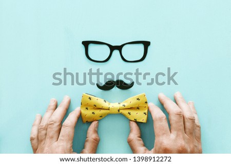 Father's day concept. Hipster glasses, mustache and bow tie on wooden background. top view, flat lay