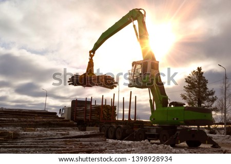 loading industrial wood with a mobile material handler to transport equipment for further processing Royalty-Free Stock Photo #1398928934