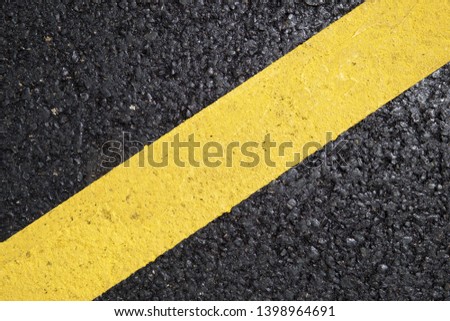 Yellow line painted on the asphalt.