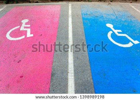 Symbol of disabled car park spaces, 2 bright colors on the street, pink and blue.