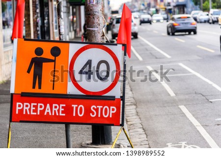 Australian "Prepare To Stop" road sign with 40 kilometres per hour speed limit and orange flags