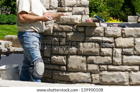 Mason building stone wall Royalty-Free Stock Photo #139900108