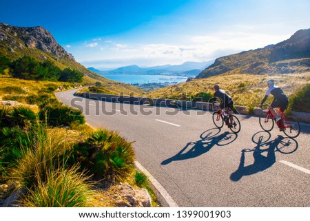 Empty Space. Sporty friends on bicycle on sunset. Couple cyclist go along coast. Sport in Nature background. Group of people two road biker in sunset. Mallorca, Majorca, Spain Royalty-Free Stock Photo #1399001903