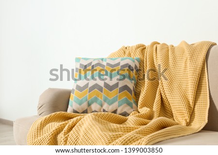 Cozy sofa with pillow and plaid near light wall. Idea for living room interior design Royalty-Free Stock Photo #1399003850