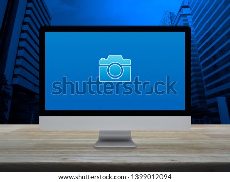 Camera flat icon with modern laptop computer on wooden table over office city tower and skyscraper, Business camera service shop online concept
