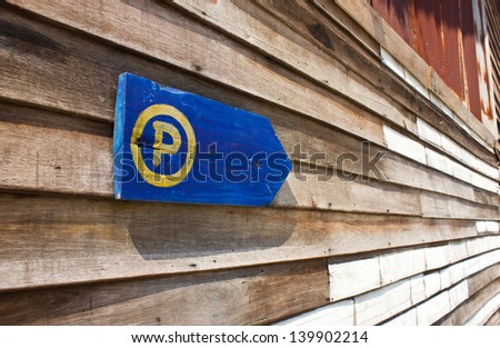 Parking sign on the old wooden wall.