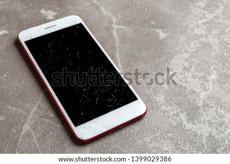 Modern smartphone with broken display on table, space for text. Device repair service