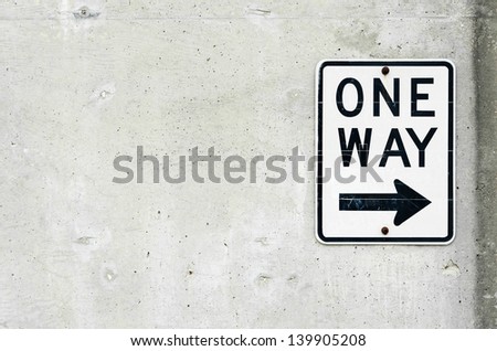 One Way Sign and Arrow on Concrete
