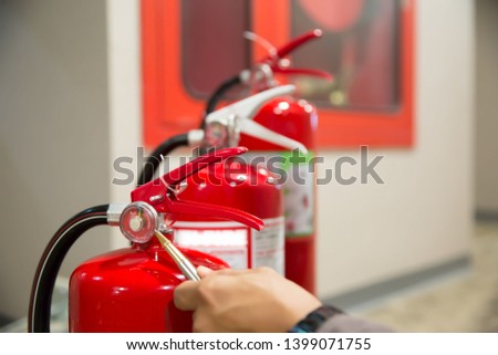 Red Fire extinguishers in the building,Engineers are checking fire extinguishers.