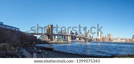 Panorama shot of Brooklyn bridge and cityscape of New York with nice calm clear blue sky in the background. Shot from Main Street Park.