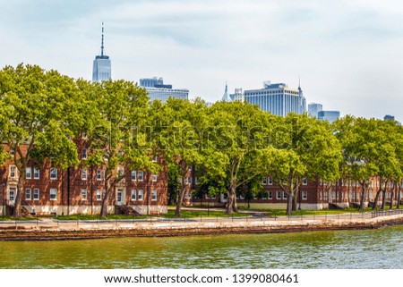 Governors Island and red old retro brick buildings near fort Jay separated from Brooklyn by Buttermilk Channel during sunny summer day in New York City, USA