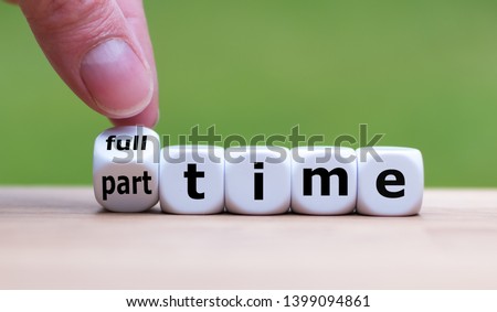 Hand is turning a dice and changes the word "full-time" to "part-time" (or vice versa). Royalty-Free Stock Photo #1399094861