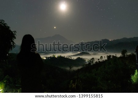 A girl gazing toward the landscape in the night