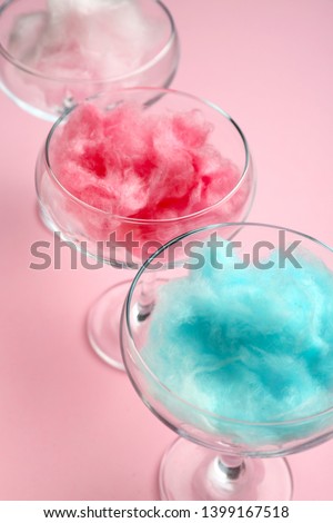Glasses with tasty cotton candy on color background