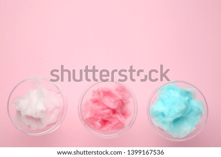 Glasses with tasty cotton candy on color background