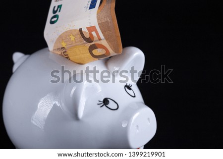 White piggy bank on a black background. White pig savings casing.