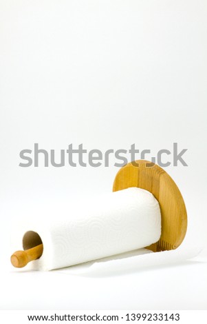 Roll kitchen paper on a wooden stand on a white background