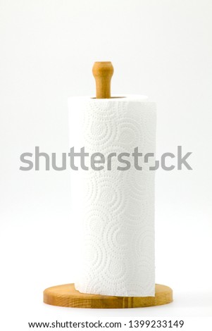 Roll kitchen paper on a wooden stand on a white background