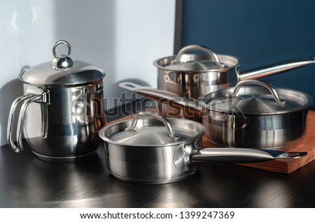 Stainless steel pots and utensils on table counter Royalty-Free Stock Photo #1399247369