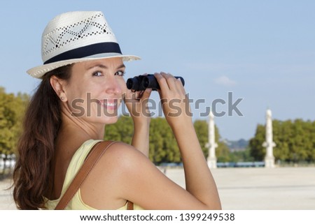 happy woman looking through binoculars