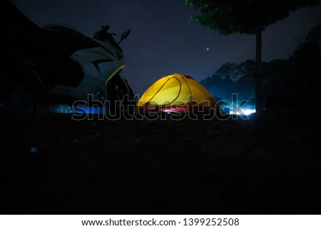 Orange tent with white motorcycle parked near
Illuminate at night in the forest