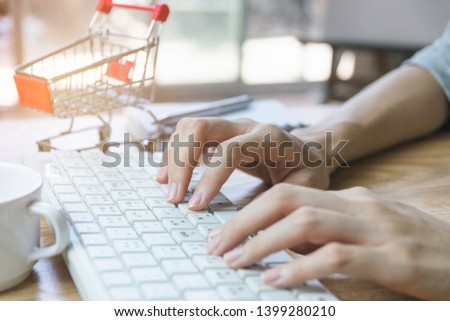 Closeup hand of woman using computer for e-commerce or shopping concept.