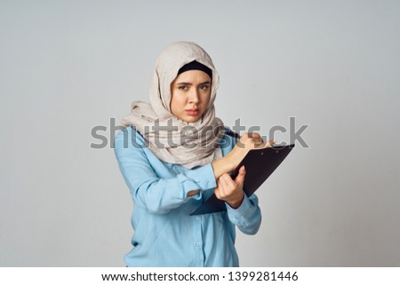    woman in burqa writes in documents                            