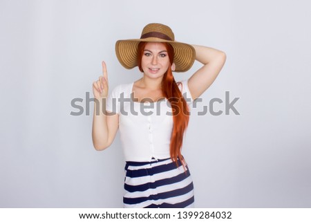Photo portrait of a beautiful redhair woman wearing summer straw hat posing isolated over white background in studio