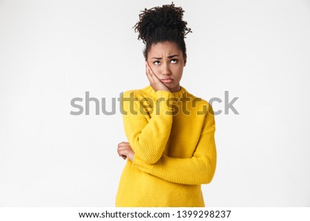 Photo of a beautiful young african confused woman posing isolated over white wall background.