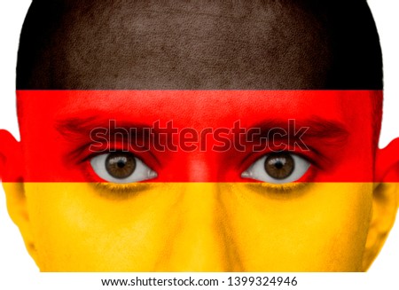 National flag Germany colored depicted in paint on a man's face close-up, isolated on a white background