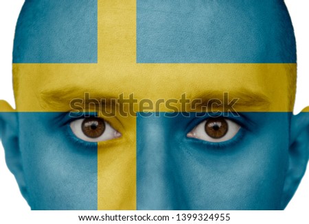National flag Sweden colored depicted in paint on a man's face close-up, isolated on a white background
