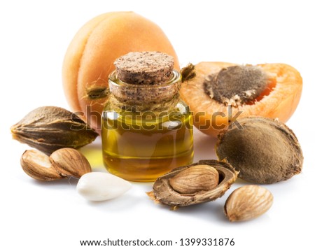 Apricot kernel oil and apricot kernels isolated on the white background. Royalty-Free Stock Photo #1399331876