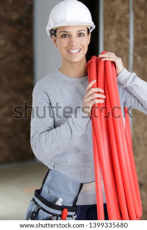 female worker holding pipes in a construction site