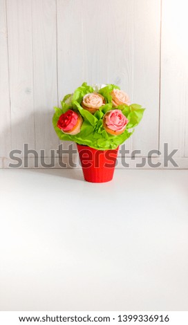 Closeup image of flowers in bouquet made of cupcakes and cakes on table at cafe or bakery. Beautiful shot of sweets and pastry over white background