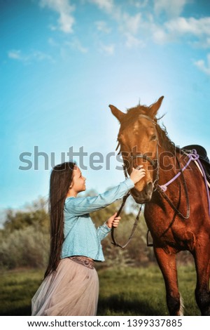 Beautiful girl with horse outdoors. Friendship and care concept image.
