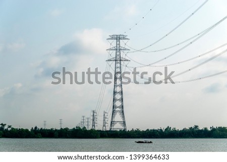 Electric pole crossing river in Mekong Delta. Vinh Long, Vietnam. 

