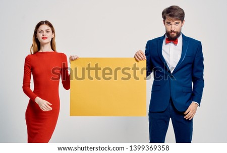 Cute couple holding yellow mocap poster advertising beauty smile