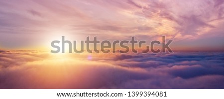 Beautiful sunset cloudy sky from aerial view. Airplane view above clouds Royalty-Free Stock Photo #1399394081