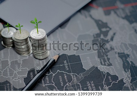 Arrange 5 coins in descending order Black wooden pencil, notebook computer And a smartphone on a black background.Rieng is a step into the concept of saving and growing interest.Copy space.