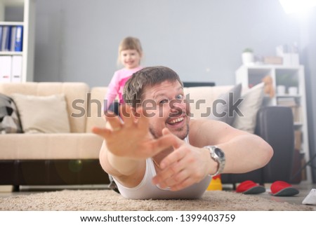 Cute little girl hold her father leg as proof of winning battle game portrait