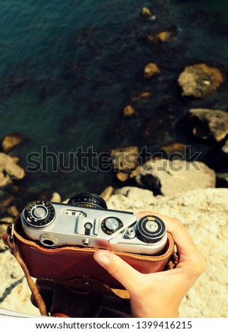 Tourist traveler photographer making pictures seascape on vintage photo camera on background yacht and boat piar, hipster girl enjoying nature holiday, mockup ocean waves view, blurred backdrop 