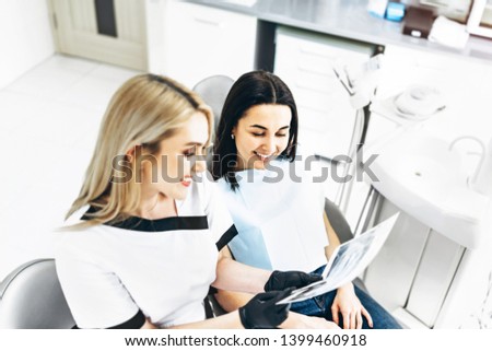 Dentist showing x-ray for the patient and explaining plan of treatment
