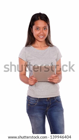 Portrait of a charming young asiatic woman looking at you and using her tablet pc on blue jeans on isolated background